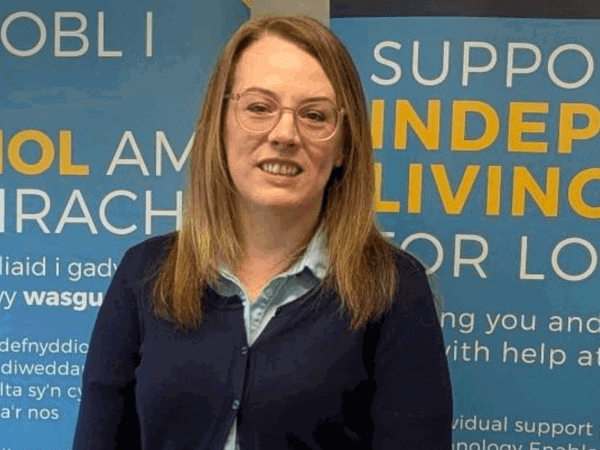 Swyddog lles cymunedol yn sefyll y tu allan i'r ganolfan byw'n dda yng Nghaerfyrddin