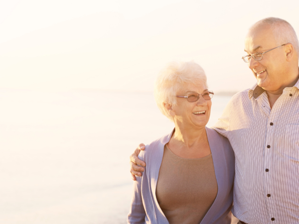 cwpl yn mwynhau eu hamser i lawr y traeth