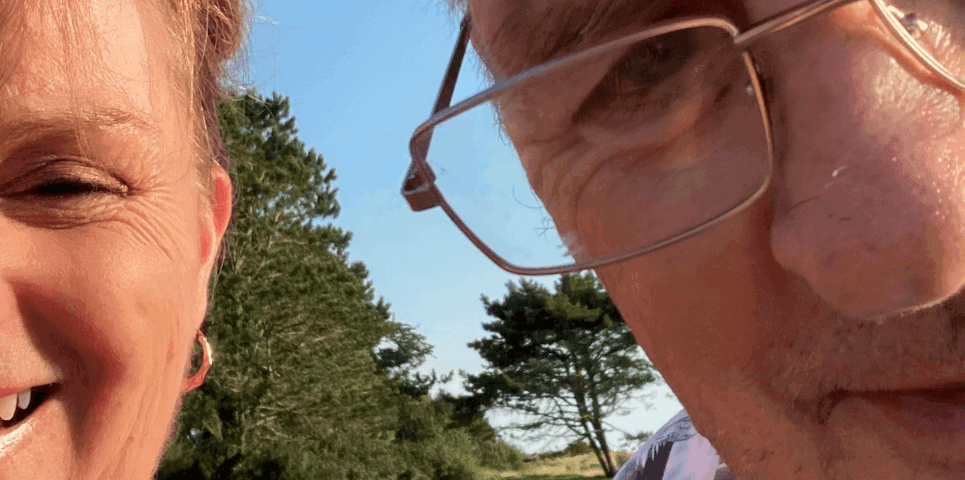 Gŵr a gwraig gyda'i gilydd yn gwenu